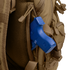 A blue training pistol is partially visible in the side pocket of a tan Condor Commuter Backpack 26L.