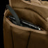 A brown mesh-textured pocket of the Condor Commuter Backpack 26L holds a black tablet with a case and stylus as part of an EDC setup.