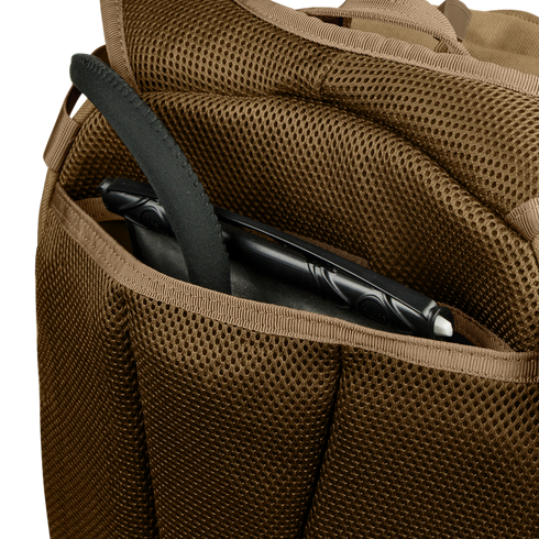 A close-up of the Condor Commuter Backpack 26L’s brown mesh pocket holding a black tablet with a protective case.