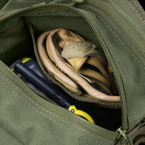 An open green Condor EDC Bag with a zipper reveals a pair of tan Condor work gloves and a yellow-and-black handheld device inside.
