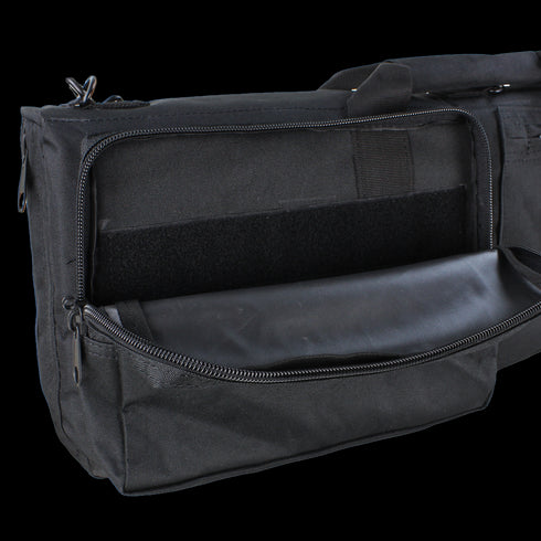 The Condor 38 Rifle Case is a black fabric bag with a large exterior zippered pocket and an empty main compartment. It has an adjustable shoulder strap for easy carrying, ideal as a rifle case or for everyday gear.
