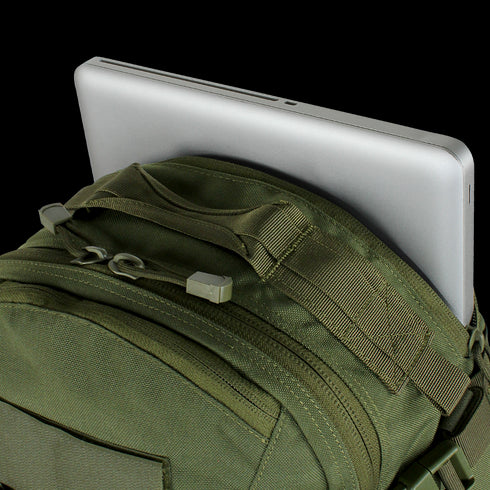 A silver laptop partially inserted into the back compartment of the Condor Venture Backpack 27.5L in Scorpion OCP, perfect for military or law enforcement professionals heading to the shooting range.