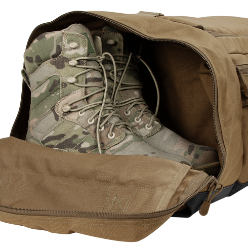 A pair of tactical camouflage military boots placed inside an open Condor Colossus Duffle Bag 60L.
