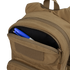 The Condor Fuel Hydration Backpack 18L in tan features a partially open zippered pocket, revealing a blue and white pen and black marker—ideal for organized gear storage on the move.