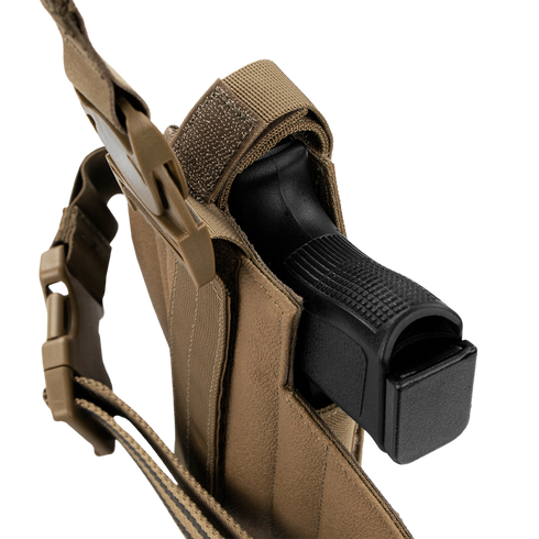 A black handgun is secured inside a Condor LCS RDS Leg Holster, a tan tactical holster with a strap and buckle, shown on a white background.