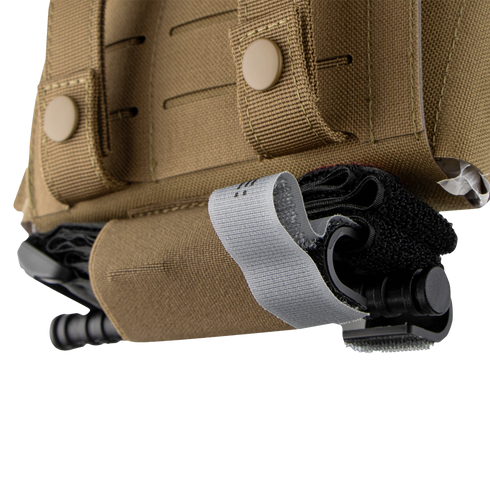Close-up of the Condor Micro TK Pouch Gen II, a tan tactical vest accessory, with a black tourniquet secured by a gray strap in its designated holder pocket.