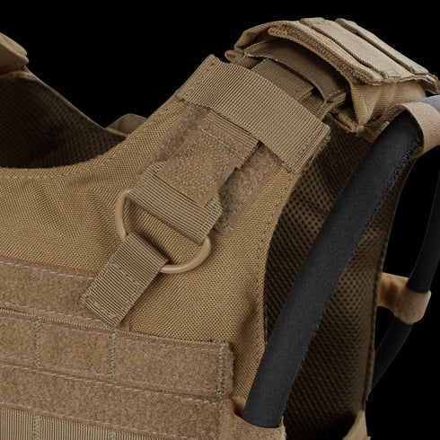 Close-up of the Condor Gunner Plate Carriers tan shoulder strap, featuring MOLLE webbing, D-ring, hook-and-loop fasteners, and hydration tube—perfect for bushcraft or law enforcement EDC.