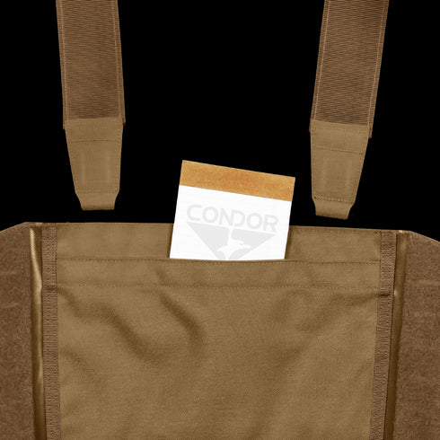A tan envelope is partially tucked into the front pocket of a Condor LCS VAS Harness Kit, a brown utility vest featuring visible straps, often used by military personnel or at shooting ranges.
