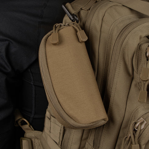 A Condor Sunglasses Case in tan, featuring a zippered design, is attached to a matching Condor tactical backpack—both crafted from durable fabric with multiple compartments and zippers.