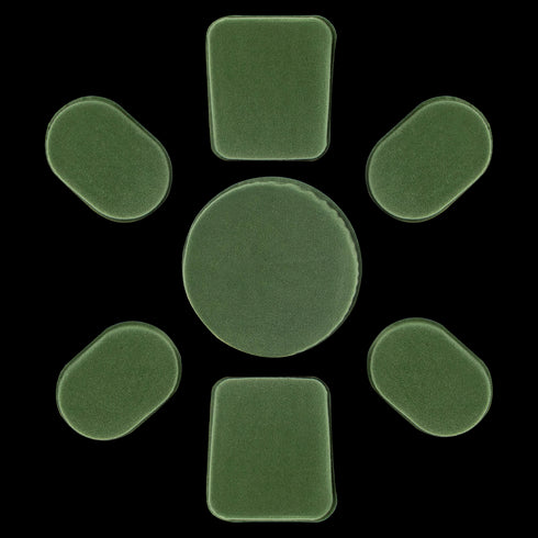 Seven green Condor Helmet Pads II, including one large round pad and six smaller rectangular and oval pads, are arranged in a circle on a white background.