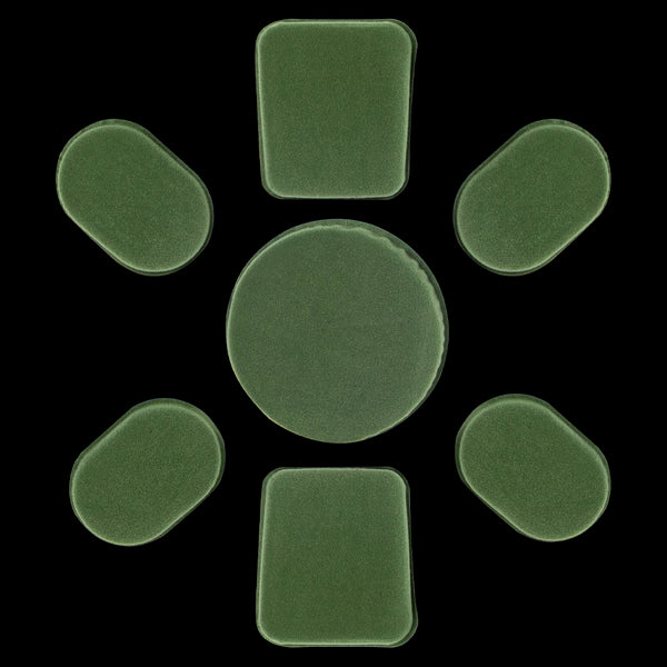 Seven green Condor Helmet Pads II, including one large round pad and six smaller rectangular and oval pads, are arranged in a circle on a white background.