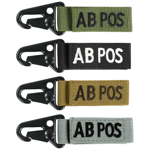 The Condor Blood Type Key Chain set includes four keychains embroidered with “AB POS” in green, black, tan, and grey, each featuring a black metal clip.