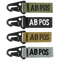 The Condor Blood Type Key Chain set includes four keychains embroidered with “AB POS” in green, black, tan, and grey, each featuring a black metal clip.
