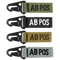 The Condor Blood Type Key Chain set includes four keychains embroidered with “AB POS” in green, black, tan, and grey, each featuring a black metal clip.