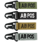The Condor Blood Type Key Chain set includes four keychains embroidered with “AB POS” in green, black, tan, and grey, each featuring a black metal clip.