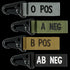 The Condor Blood Type Key Chain set features four fabric keychains with plastic clips, each in a unique color and labeled O POS, A NEG, B POS, or AB NEG.