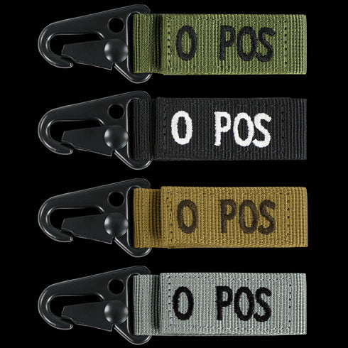 The Condor Blood Type Key Chain set includes four fabric keychains with black metal clips, labeled O POS in white or black, and comes in green, black, tan, and gray.