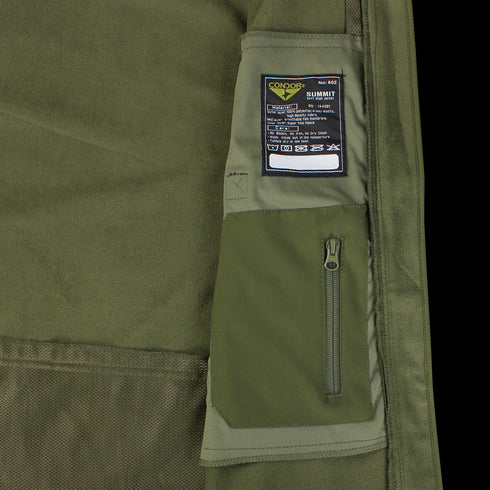 Close-up of the olive green Summit Softshell Jacket by Condor, featuring a tactical hood, zippered pocket, and a label with washing instructions and Condor branding.