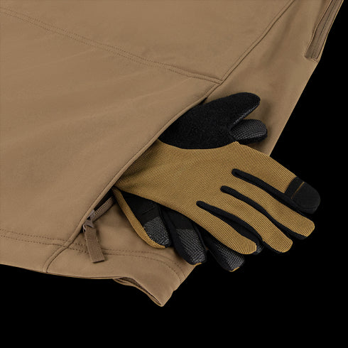 A pair of brown and black work gloves with thermal insulation are partially tucked into the zippered pocket of a tan Condor Summit Softshell Jacket.