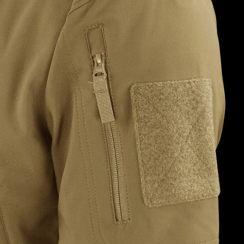 Close-up of the Condor Summit Zero Softshell Jacket’s tan sleeve, highlighting a vertical zipper pocket and a rectangular hook-and-loop patch.