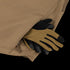 A Summit Zero Softshell Jacket by Condor in tan has tan and black work gloves partially tucked into its zippered side pocket.