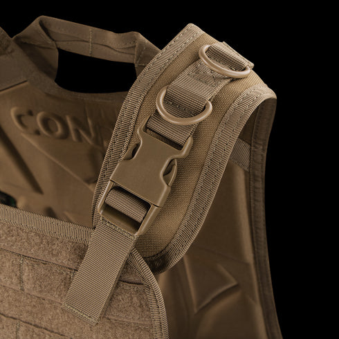 Close-up of the Condor Compact Plate Carrier’s shoulder strap, showing a plastic buckle, dual metal D-rings, and reinforced stitching on brown fabric—perfect for law enforcement or EDC use.