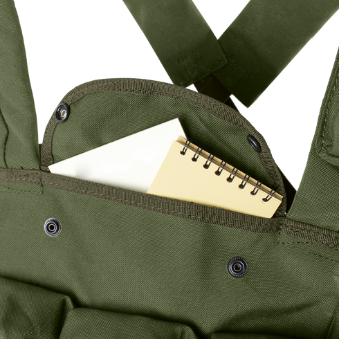 A small spiral notebook partially tucked into the front pocket of a Condor 7-Pocket Chest Rig in olive green, featuring metal snap buttons.
