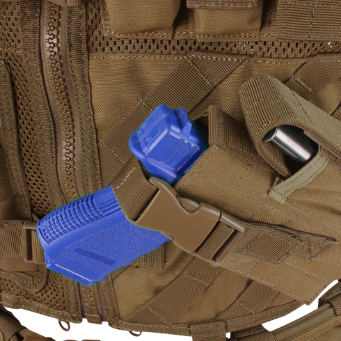 Close-up of the Condor Cross Draw Vest in tan, featuring a blue training pistol in a holster secured with a brown buckle strap.