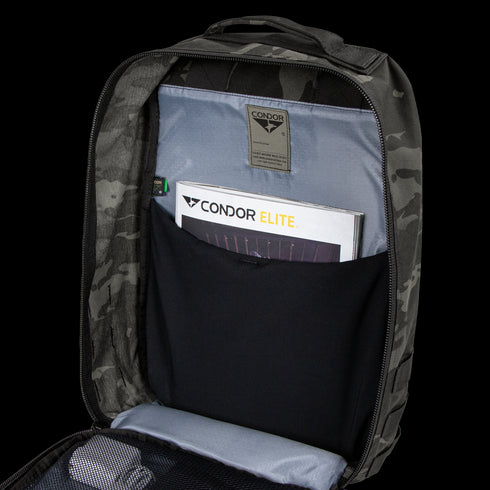 Open Condor Prime Pack 21L in MultiCam Black revealing an interior pocket with a Condor Elite booklet and a mesh zippered compartment.