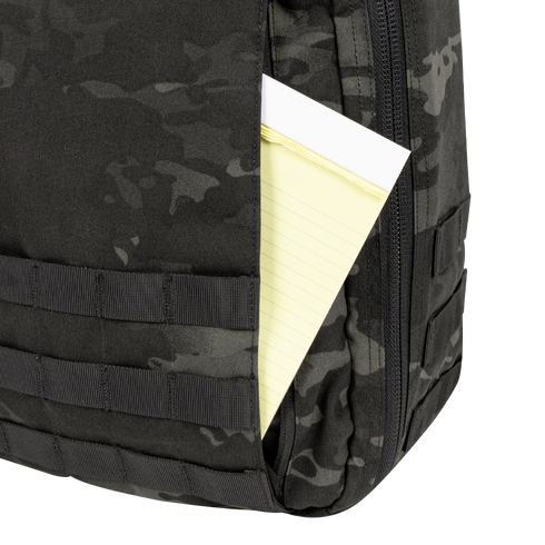 A yellow legal pad is partially visible in the front pocket of a Condor Prime Pack 21L backpack in MultiCam Black.