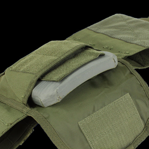 A close-up of the Condor Defender Plate Carrier in green, featuring an open pocket that reveals a ballistic plate inside.