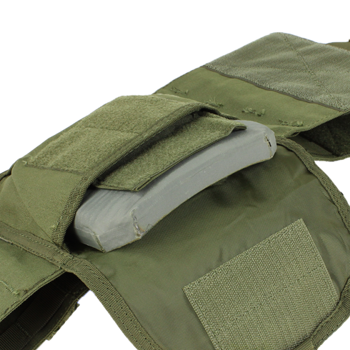 A close-up of the Condor Defender Plate Carrier in green, featuring an open pocket that reveals a ballistic plate inside.