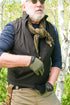 A bearded older man in sunglasses, gloves, scarf, tactical vest, and outdoor EDC gear stands among green foliage and white tree trunks, wearing the Condor Maxfort Long Sleeve Training Top.