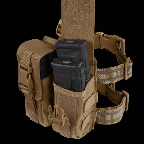 The Condor Drop Leg M4 Mag Pouch is a tan tactical pouch with adjustable straps and buckle closures, designed to securely hold two black rifle magazines.