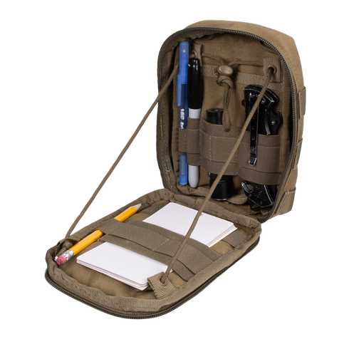 The Condor Sidekick Pouch in khaki opens to reveal pens, a flashlight, a multitool, a whistle, a pencil, and a notepad neatly secured with interior elastic straps.