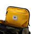 The Nomad Backpack 25L by Condor features a black and olive green exterior, an open view of its yellow mesh zippered pocket, and a signature Condor Elite label.