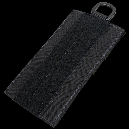 The Condor TSRS Shotshell Platform is a black rectangular fabric patch featuring a vertical hook-and-loop strip and a metal D-ring, designed for secure shotshell storage in tactical law enforcement or military environments.