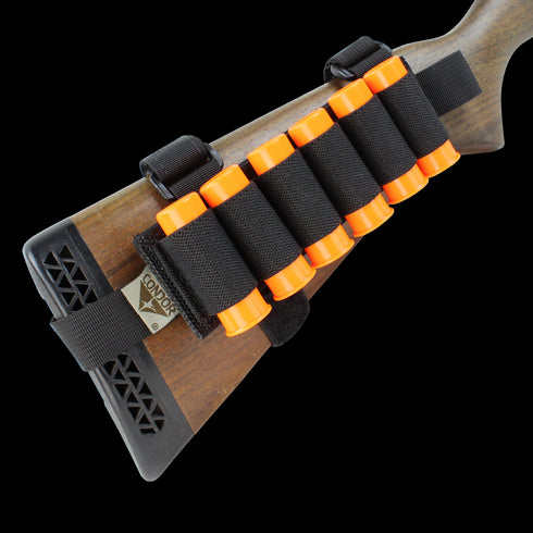 The Condor TSRS Buttstock Shell Platform features a black elastic holder attached to a shotgun buttstock, holding six orange shells and displaying the Condor brand tag.