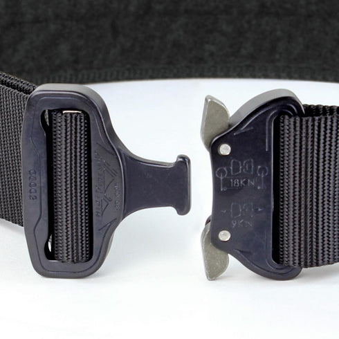 Close-up of the Condor Cobra Tactical Belt, featuring a black nylon strap and metal quick-release buckle, displayed unfastened on a white surface against a dark background.