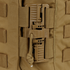 Close-up of a brown plastic buckle with a securing cord on the Condor Cyclone RS Plate Carrier in MultiCam Black, shown on tan fabric.