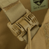 Close-up of a tan plastic buckle on the Condor Cyclone RS Plate Carrier - MultiCam Black, secured to a nylon strap, with part of a Made in USA label visible in the background.