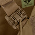 Close-up of a tan buckle fastener on a fabric strap, attached to brown material with visible stitching and a Made in USA label—part of the Condor Cyclone RS Plate Carrier, perfect for EDC or bushcraft gear.