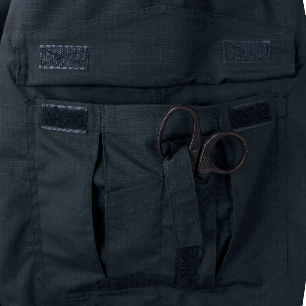 A pair of trauma shears is secured in a black fabric pocket with Velcro fasteners on the Condor Womens Protector EMS Pants.