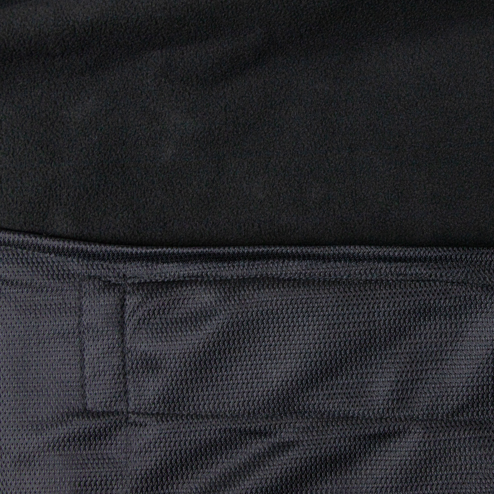 Close-up of two black fabrics from the Condor Core Softshell Vest. The upper fabric is soft and fleecy, ideal for comfort, while the lower section features a textured, woven pattern with visible stitching—perfect for bushcraft or EDC.