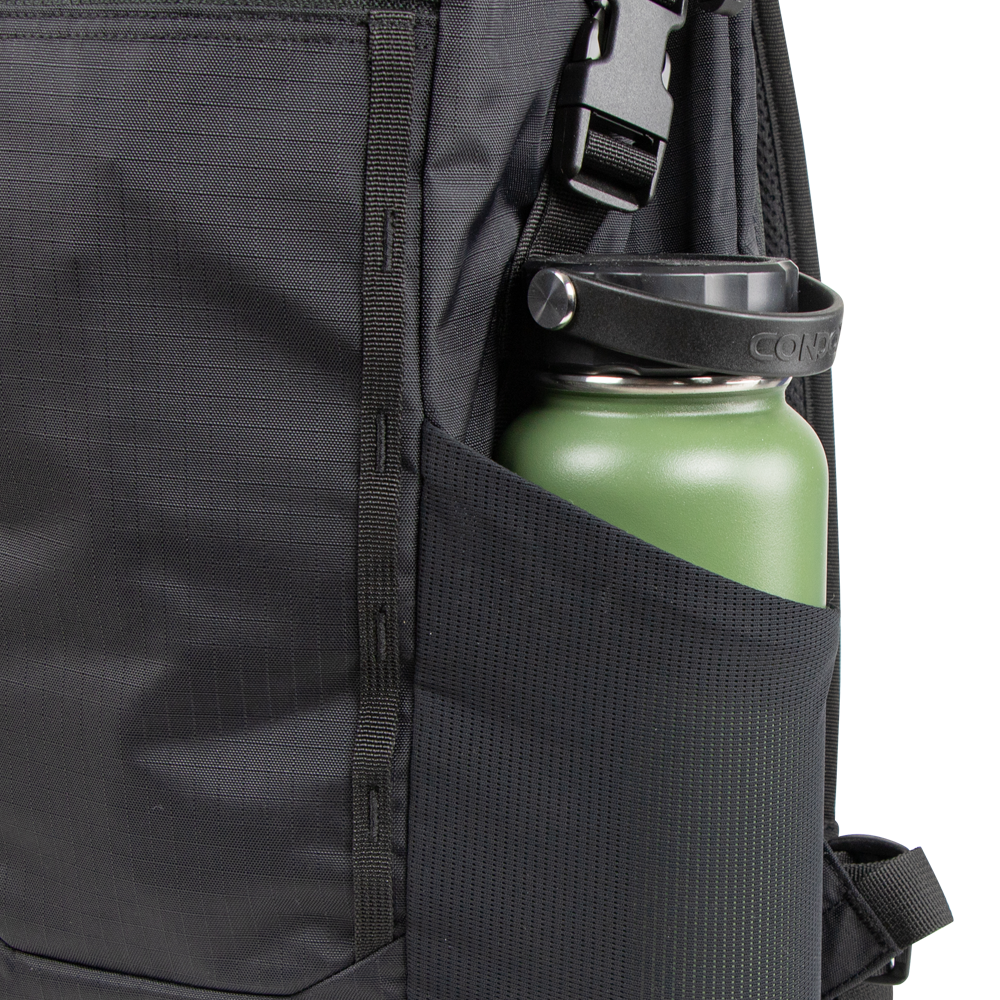 Close-up of a Condor Aero Roll-Top Backpack 25L in black, featuring military-inspired design, with a green reusable water bottle in the side mesh pocket.