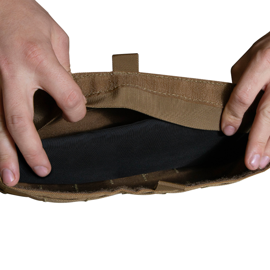 Two hands open a tan Enforcer Releasable Plate Carrier by Condor, revealing black interior details and MOLLE webbing against a white background.