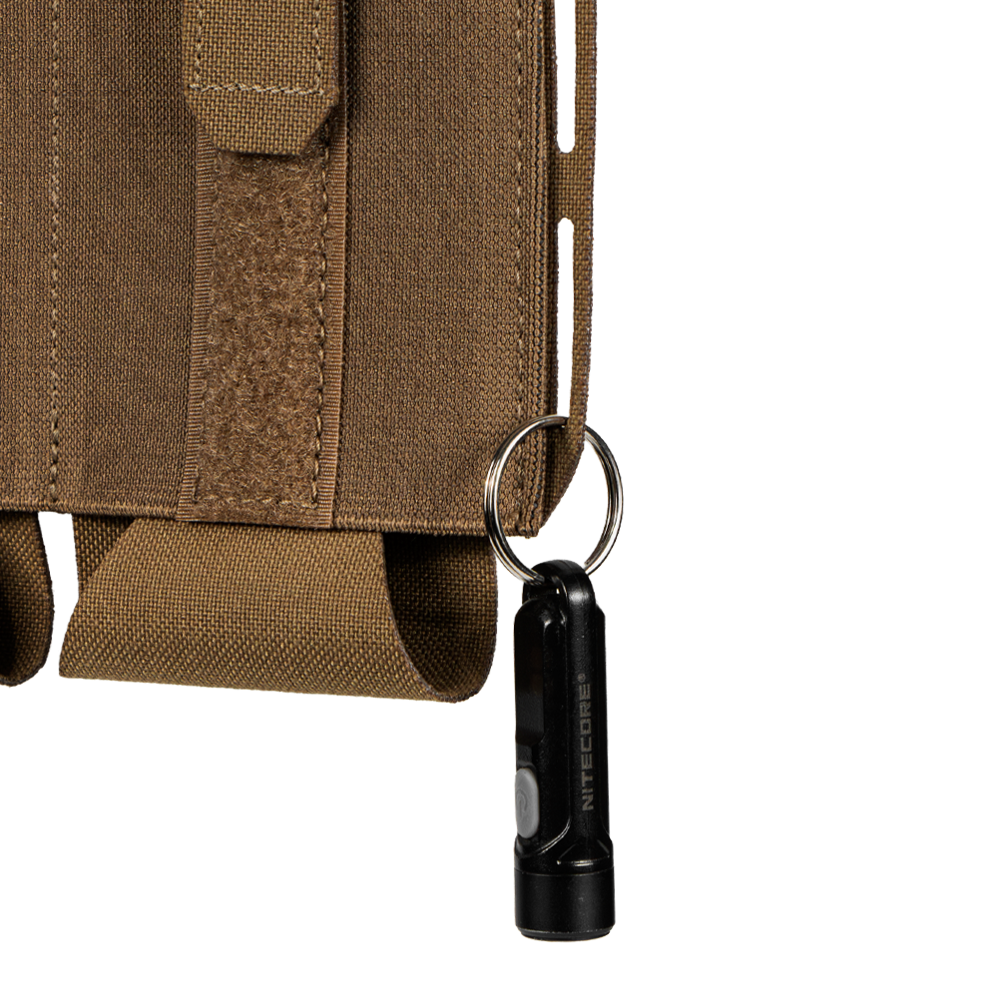 A small black flashlight with a keyring is attached to a Condor VAS Flex Placard tactical bag.