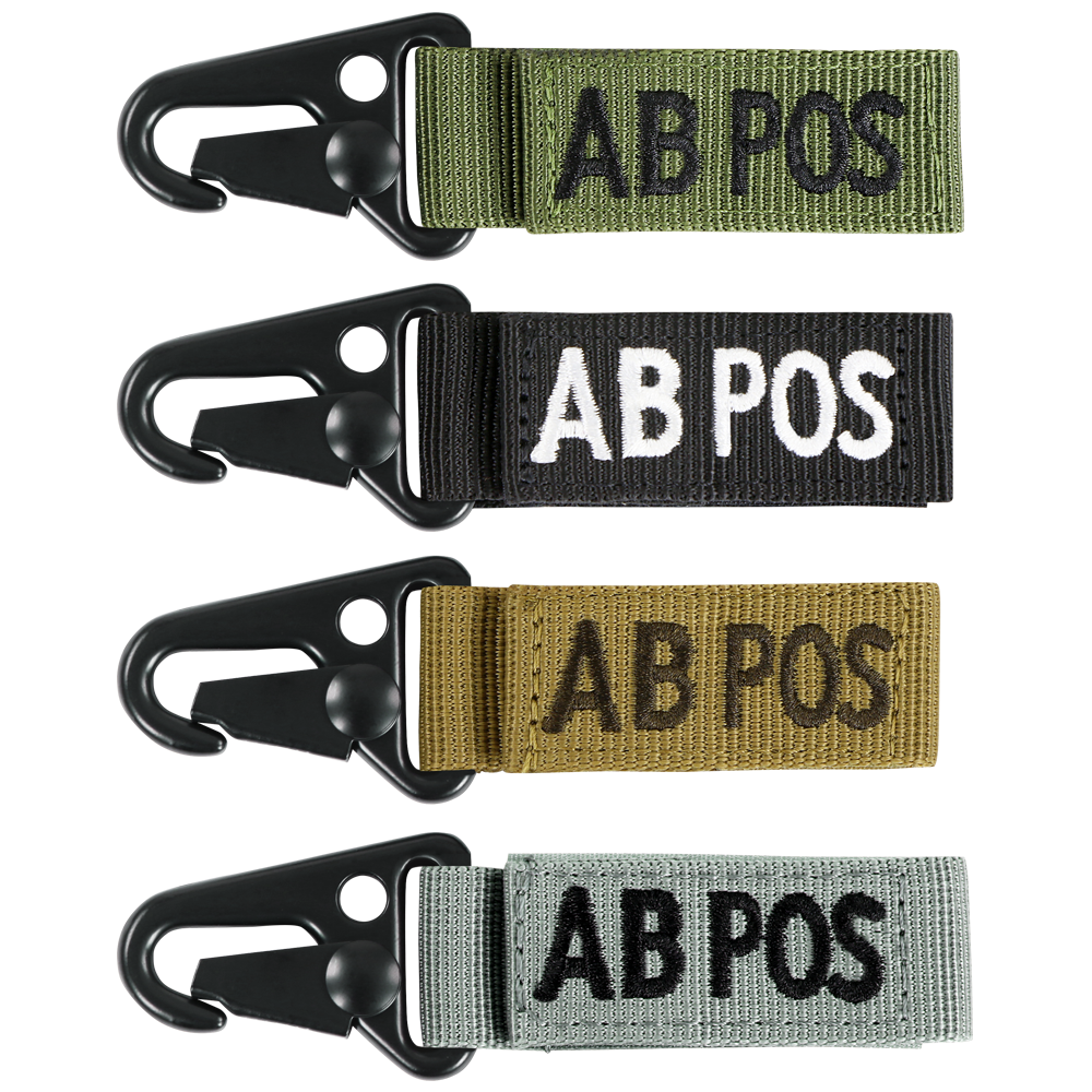 The Condor Blood Type Key Chain set includes four keychains embroidered with “AB POS” in green, black, tan, and grey, each featuring a black metal clip.