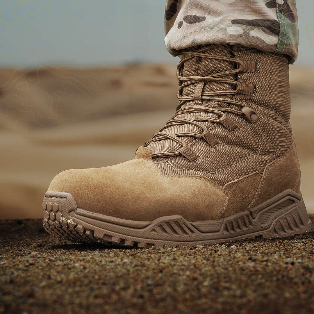 Close-up of the Condor Brigade 8″ Tactical Boots - AR670 in tan, featuring rugged soles on sandy ground, worn by a person in camouflage pants.