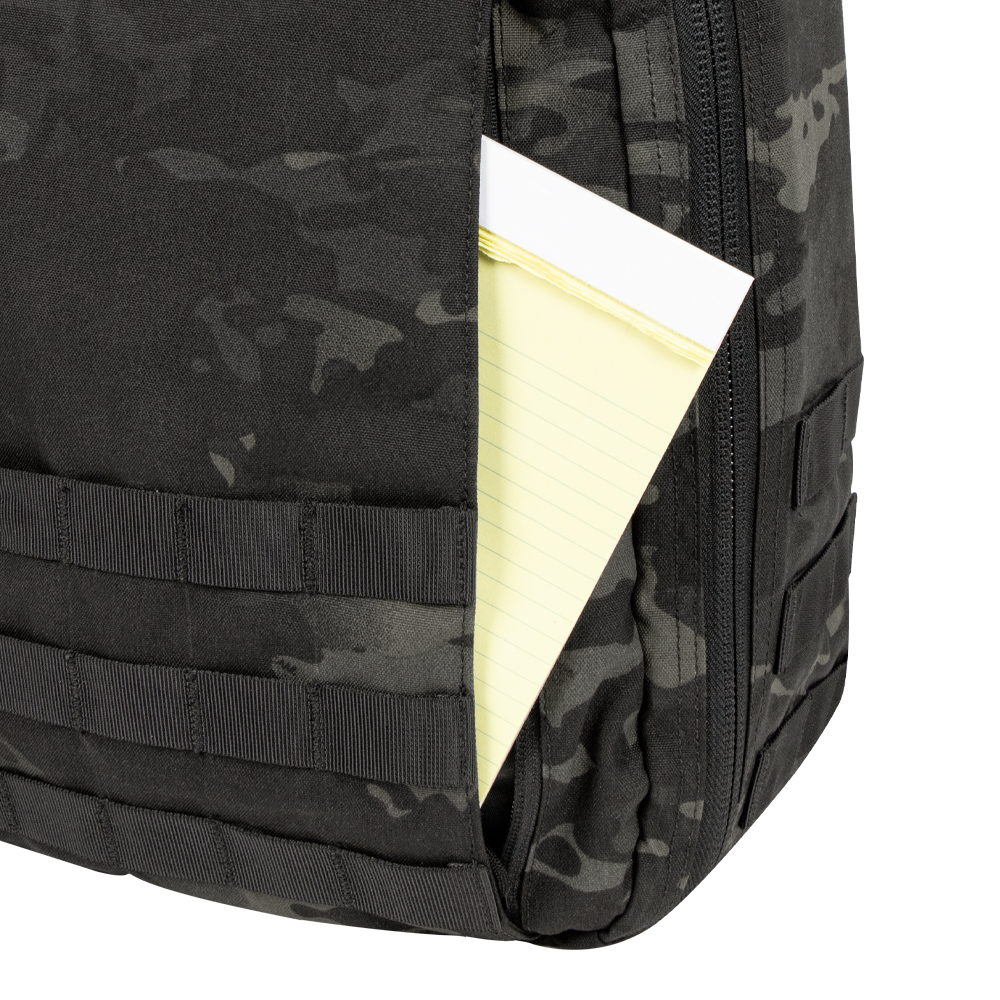 A yellow legal pad is partially visible in the front pocket of a Condor Prime Pack 21L backpack in MultiCam Black.